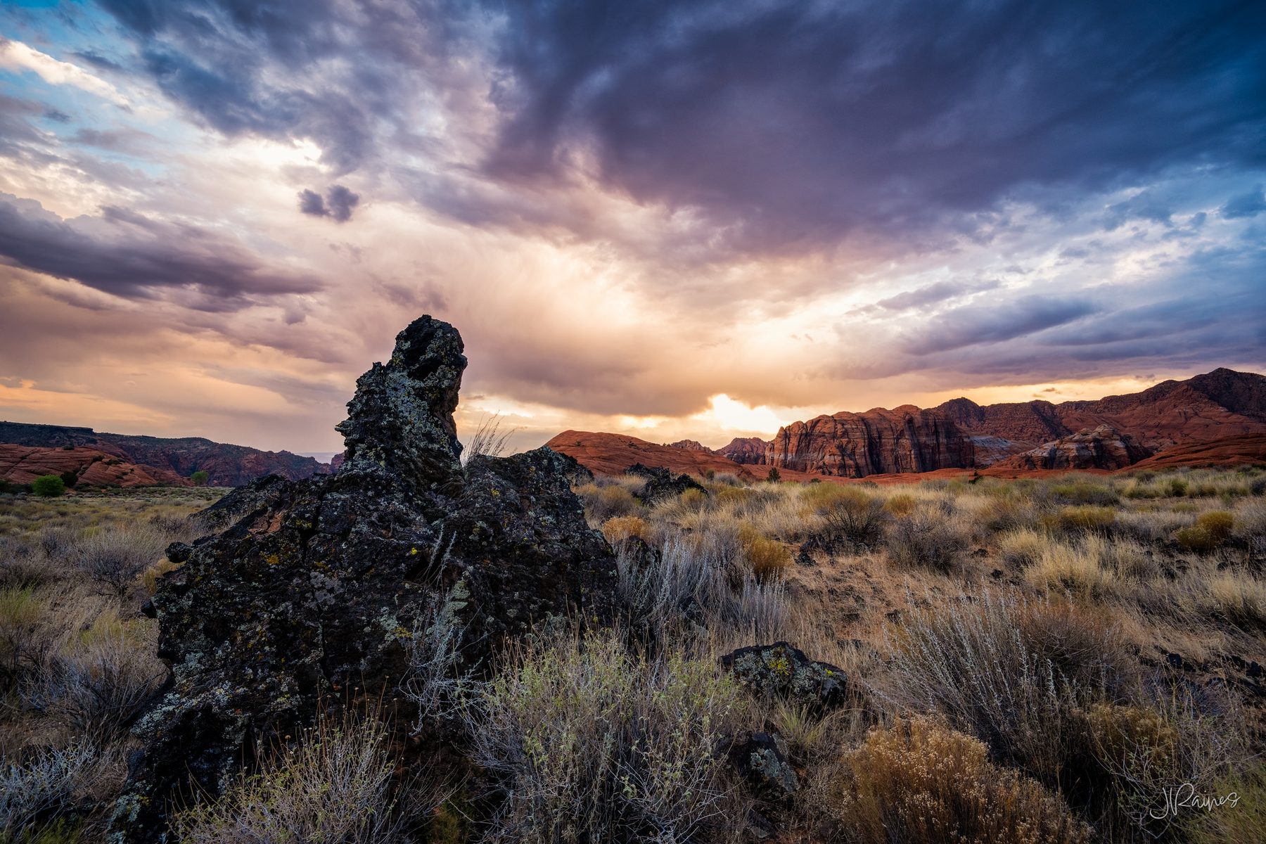 Lava rock formation silhouetted against a stormy sunset in Snow Canyon, Utah