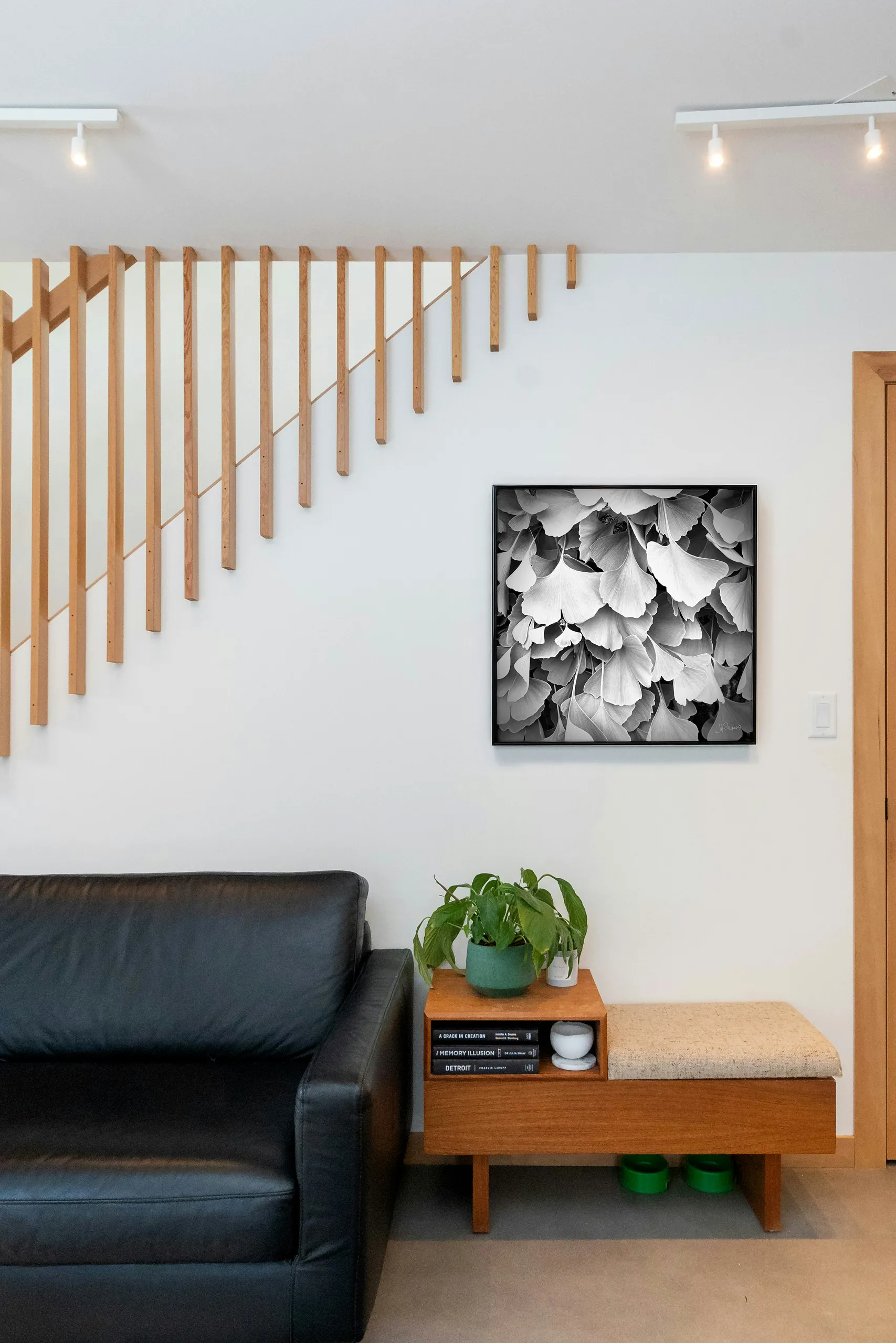 Fantail, a square print, hung in a stairwell nook above a bench