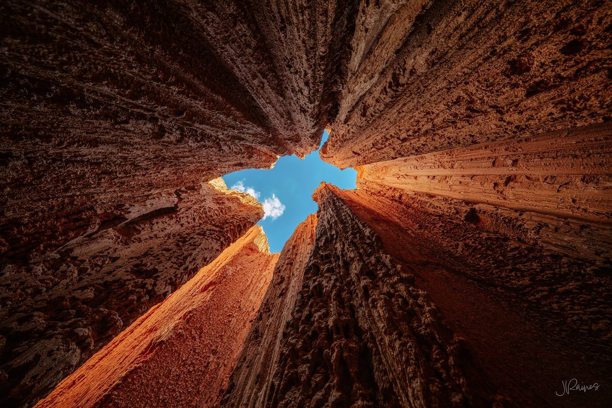 Looking straight up out of a narrow slot at Cathedral Gorge State Park, Nevada, where the clay walls close to a sliver of sky