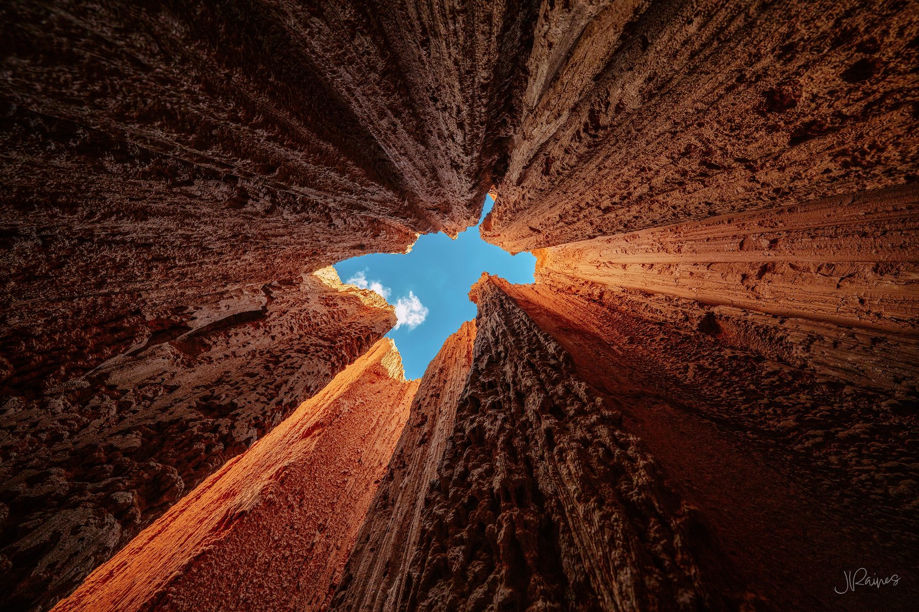 Looking straight up out of a narrow slot at Cathedral Gorge State Park, Nevada, where the clay walls close to a sliver of sky