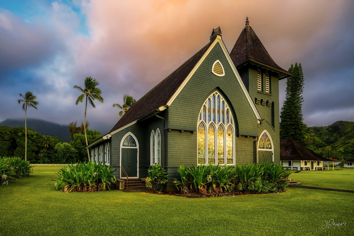 A historic mission church on Kauai, Hawaii, under a breaking sky