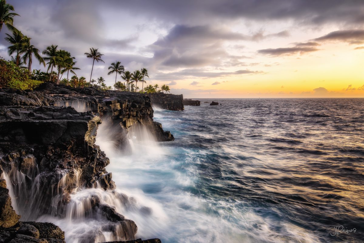 Kona coast in Hawaii with waves crashing into volcanic cliffs