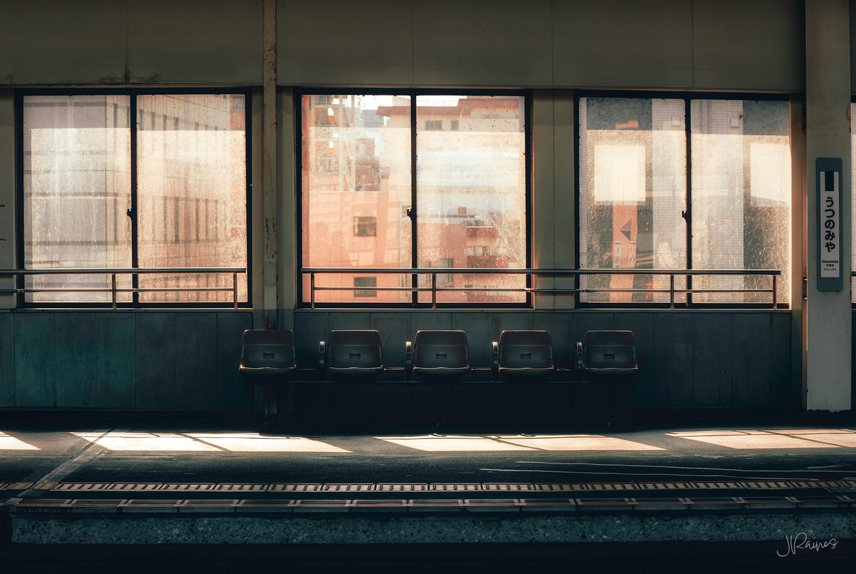 An abandoned interior in Japan, the seats still in rows and the light coming through what is left of the windows