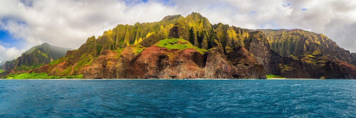 The Nā Pali Coast on Kauai, Hawaii, where the cliffs drop straight into the Pacific and the ridgelines run back into the island in a series of fluted green walls