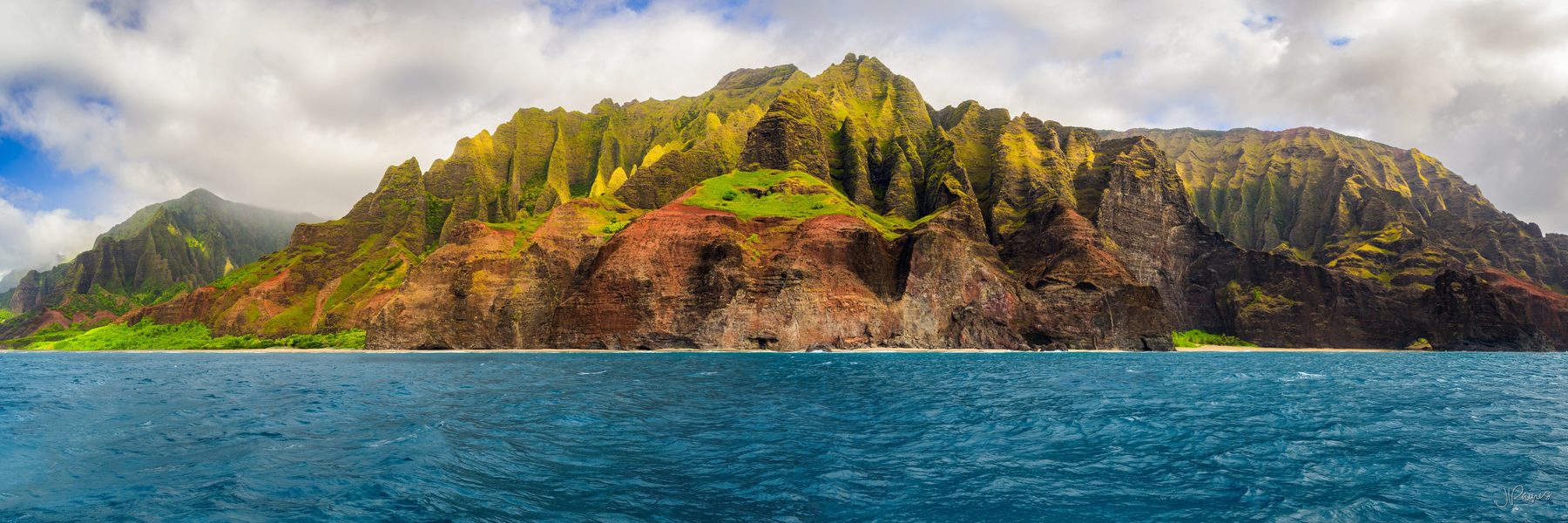 The Nā Pali Coast on Kauai, Hawaii, where the cliffs drop straight into the Pacific and the ridgelines run back into the island in a series of fluted green walls