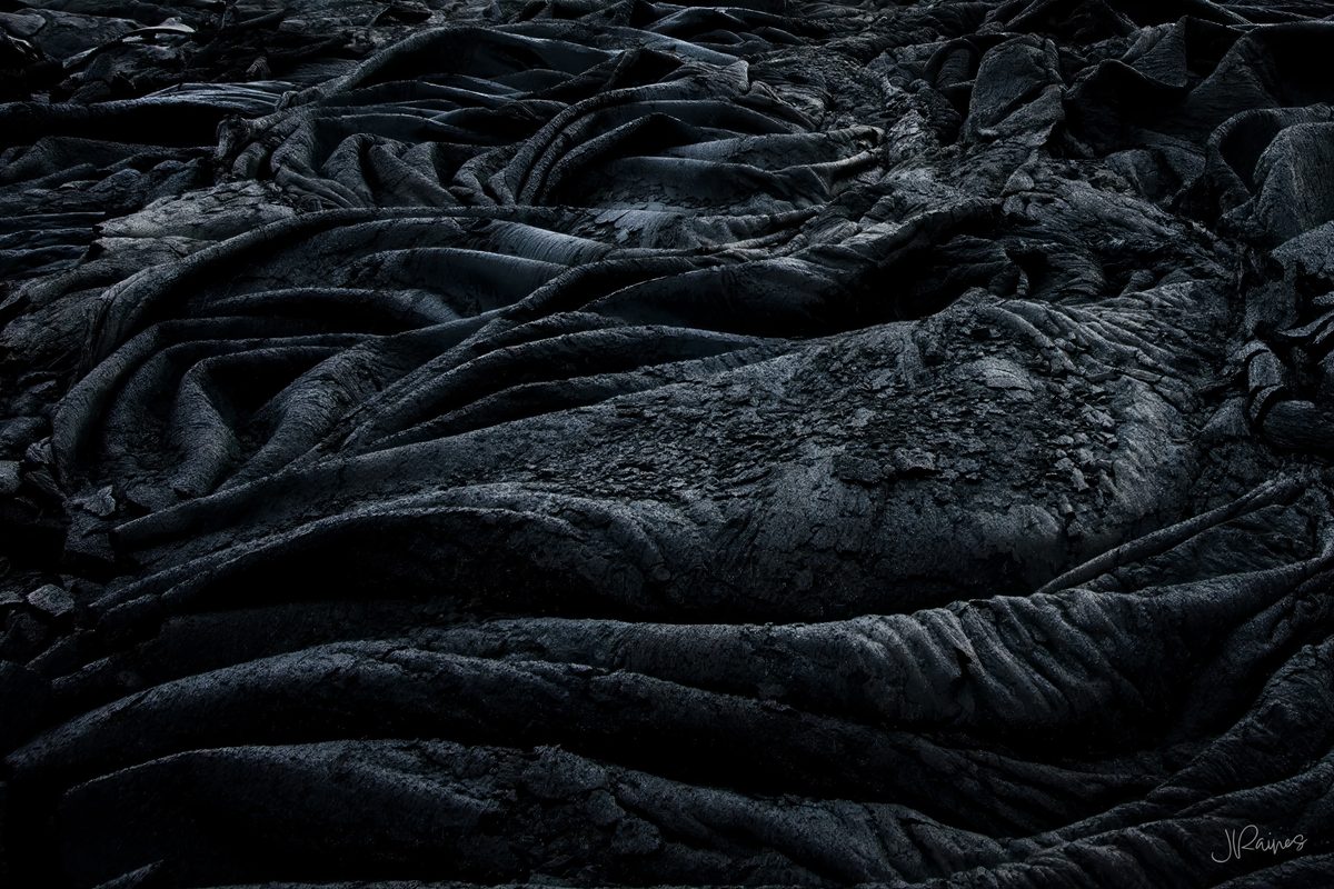 Solidified black pahoehoe lava with rope-like folded texture, Hawaii Volcanoes National Park, Hawaii