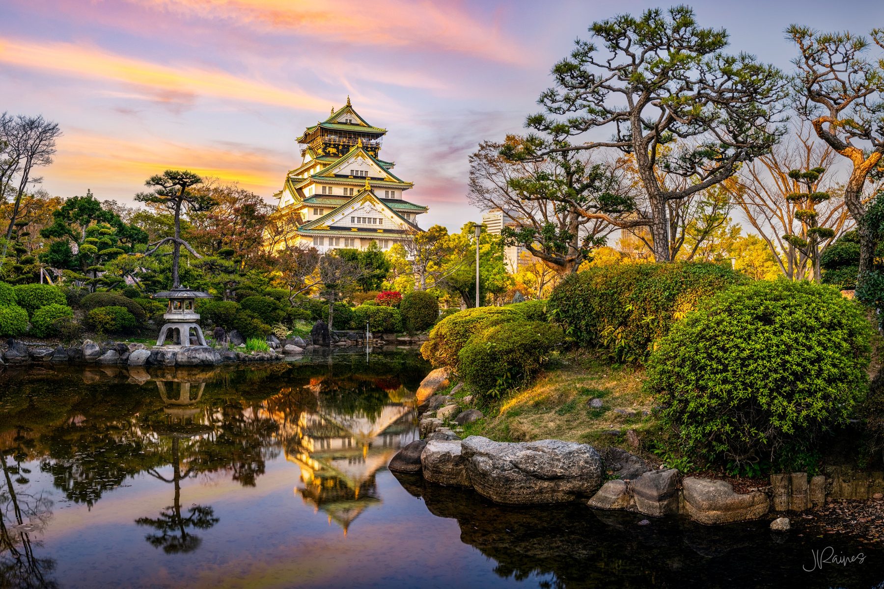 Osaka castle with reflection in pond and garden