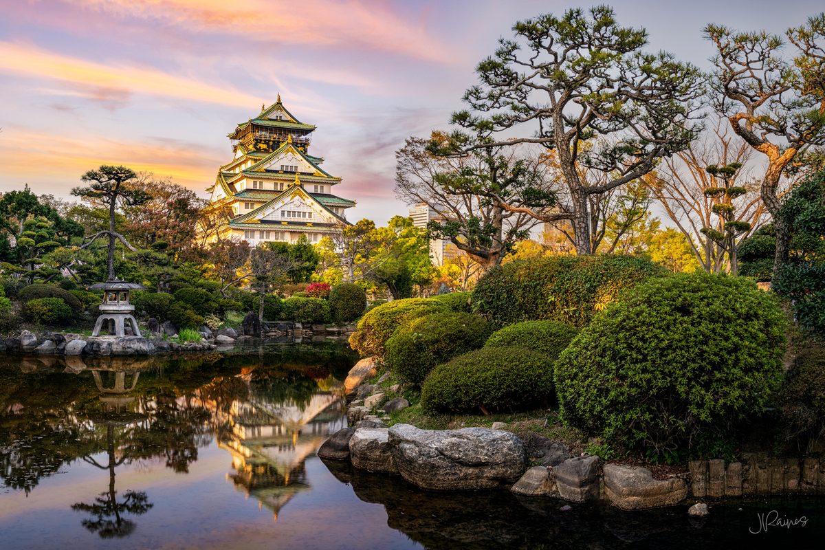 Osaka castle with reflection in pond and garden