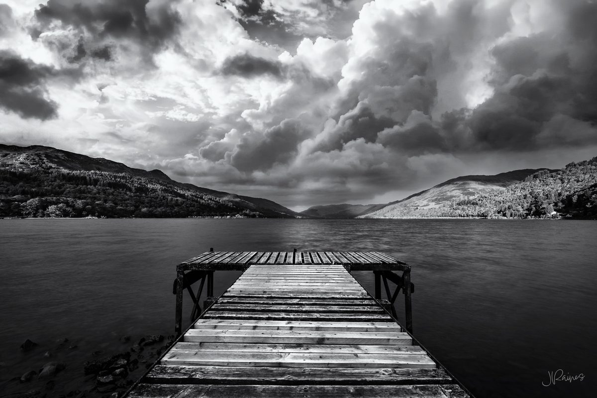 Pier at Loch Earn looking out at the water with storm clouds, Southern Highlands, Scotland