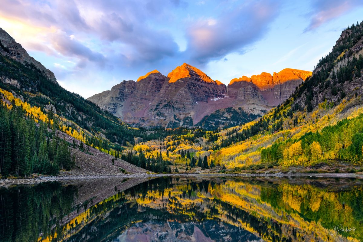 Maroon Bells mountains reflecting in lake at sunrise, Aspen, Colorado